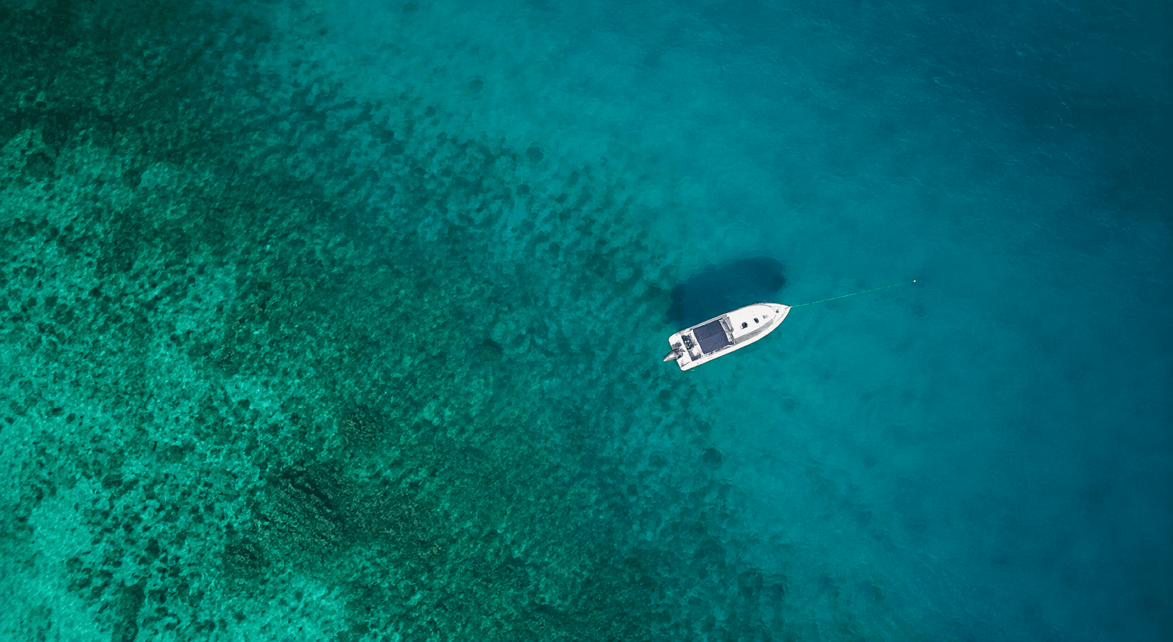 Small boat on deep blue water from above